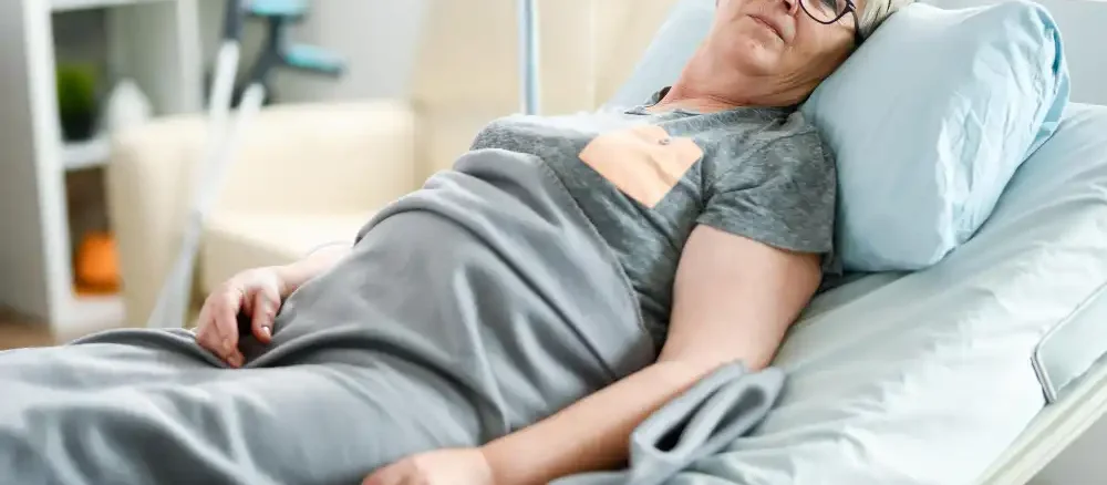 Older woman resting in an adjustable bed as part of a pressure-relief care routine showing **how to prevent bedsores**.